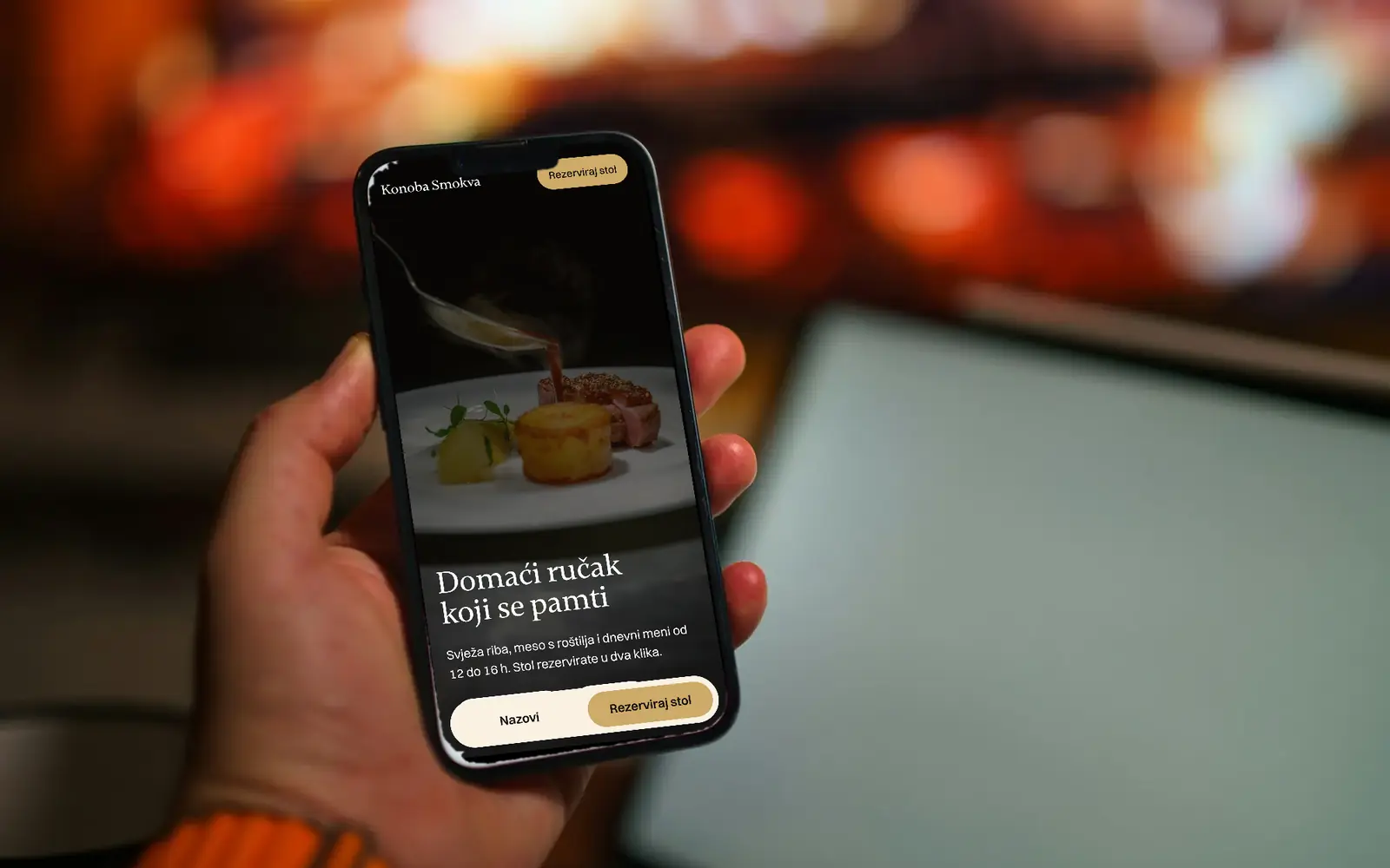 Ruka drži mobitel na kojem je otvorena stranica restorana